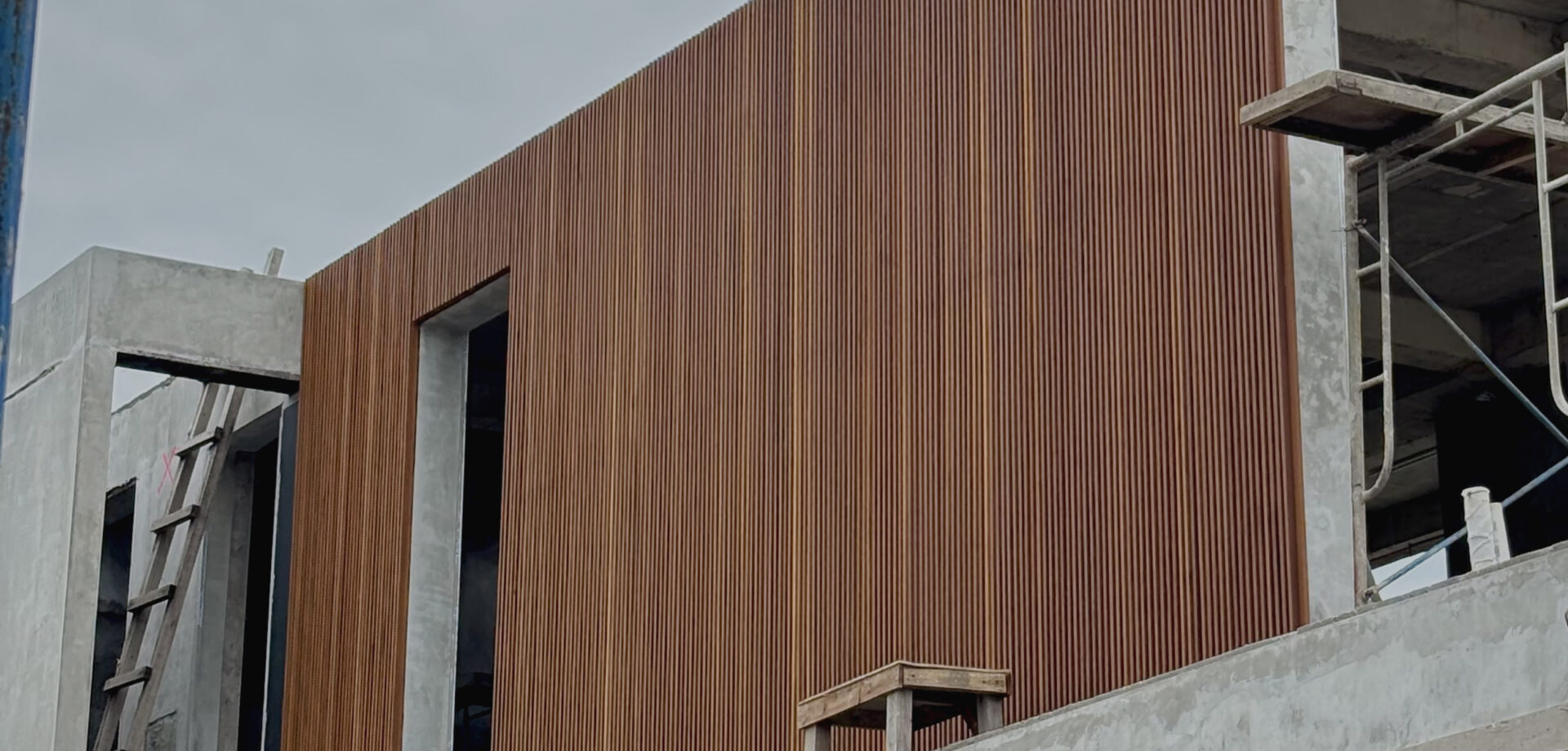 Vertical timber batten cladding on a concrete building under construction