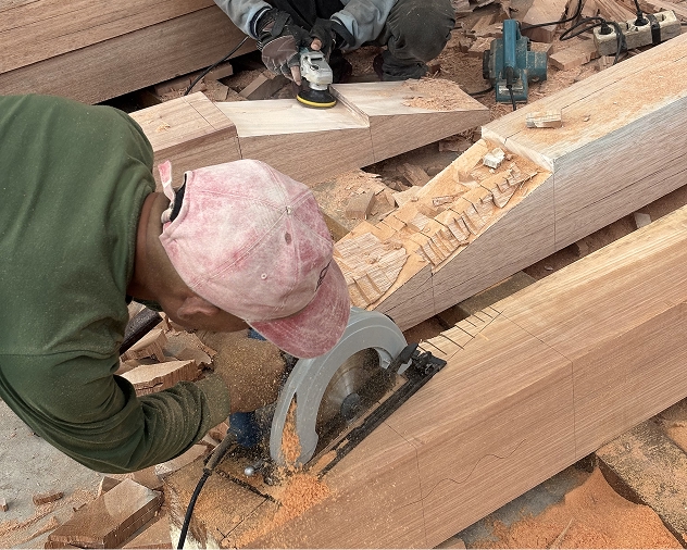 Craftsman shaping a hardwood beam with a circular saw amid wood shavings