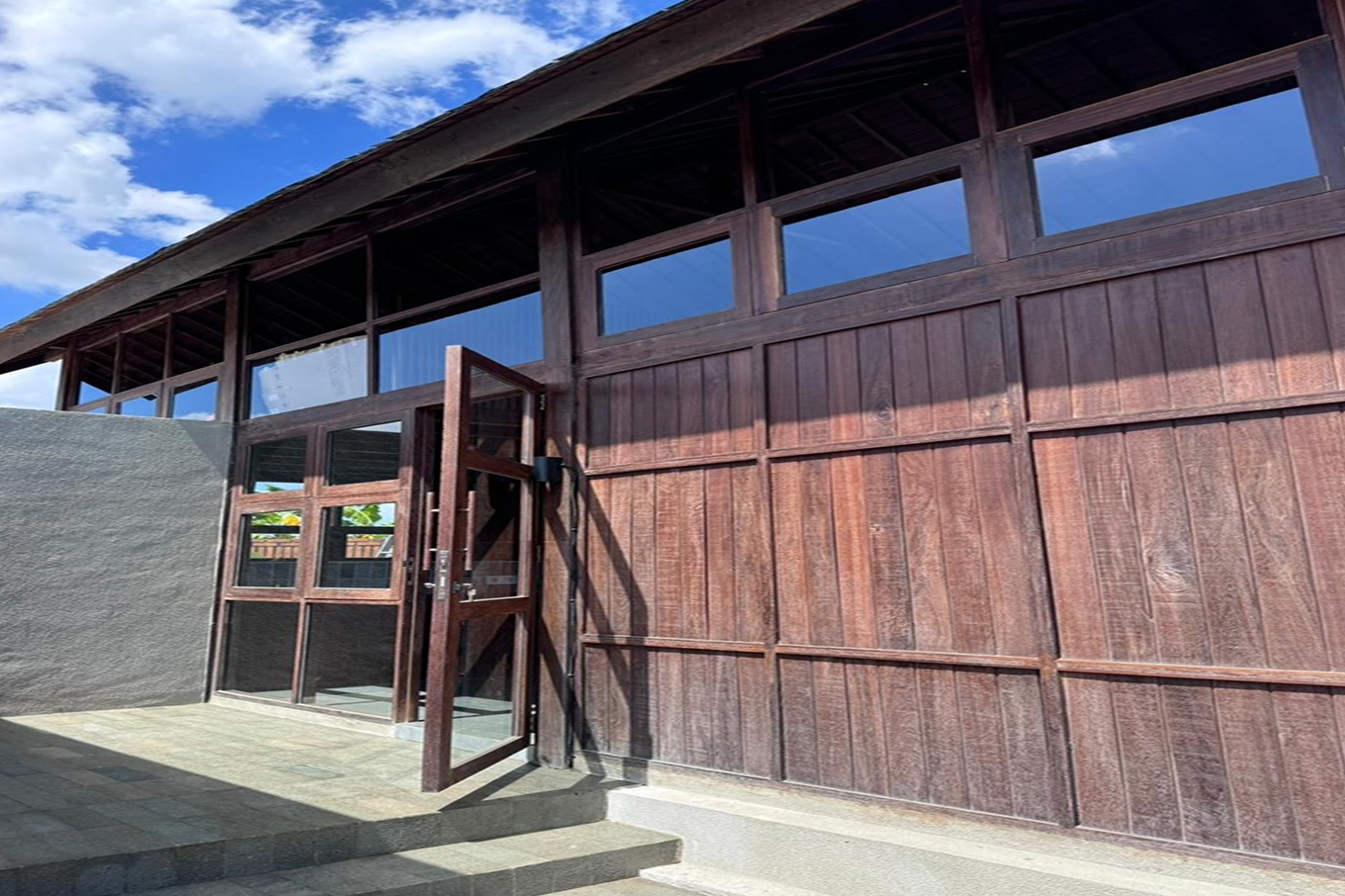 Reclaimed dark hardwood wall cladding in vertical planks on a Bali villa with clerestory windows